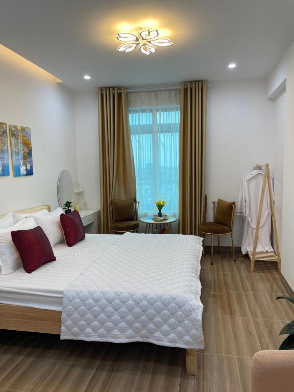 ein Schlafzimmer mit einem großen weißen Bett mit roten Kissen in der Unterkunft Nhà Nghỉ Huyền Anh in Hanoi