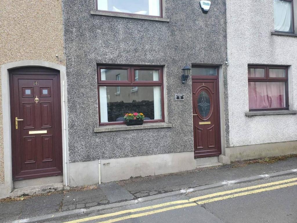two brown doors on the side of a building at Beautiful 2-Bed House in Larne with free parking in Larne