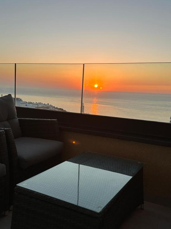 une chambre avec un canapé, une table et un coucher de soleil dans l'établissement Welcome to THE VIEW!, à Al Hoceïma