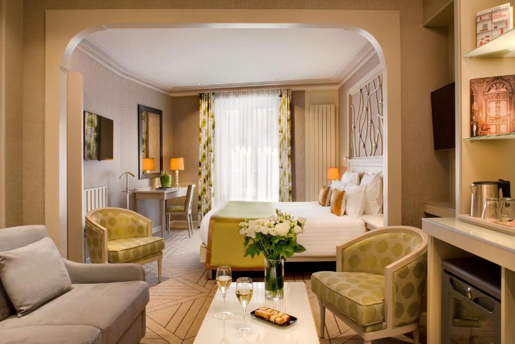 une chambre d'hôtel avec un lit et un salon dans l'établissement Rochester Champs Elysees, à Paris