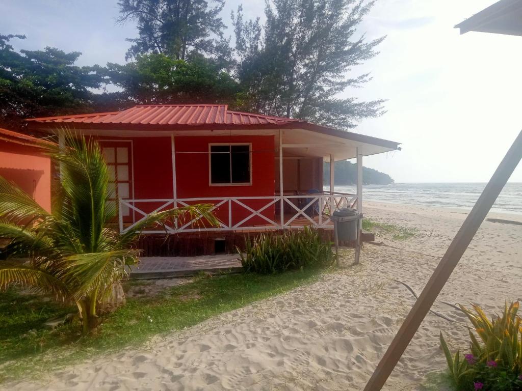 een rood huis op het strand bij Tumombuvoi Homestay (Sidi place) in Tiga Papan