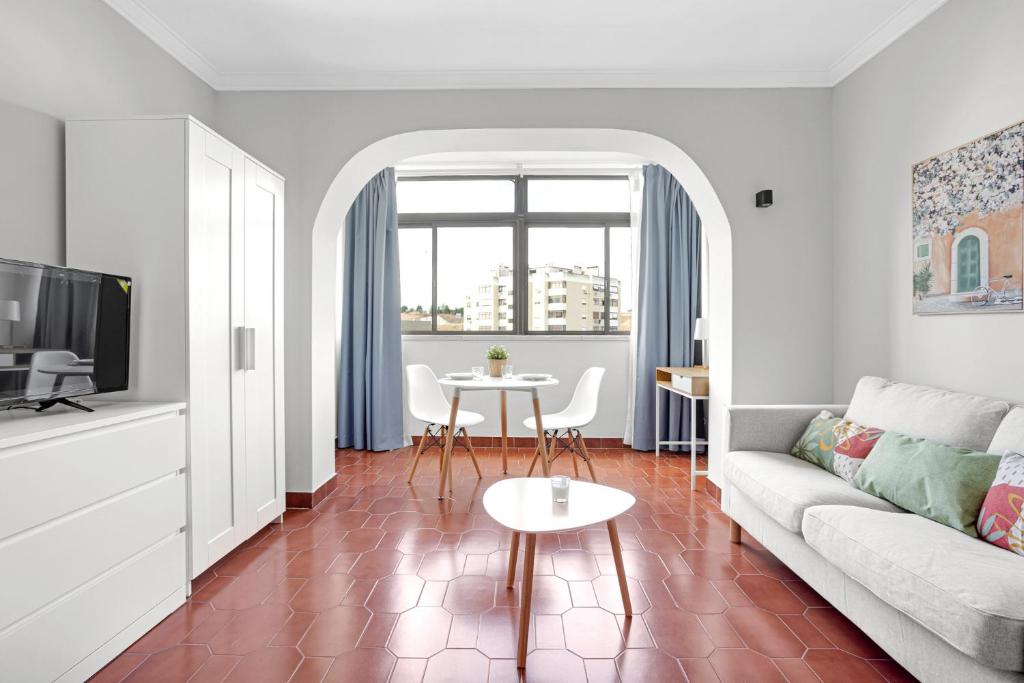 salon z kanapą i stołem w obiekcie Wonderful Shared Apartment in Alfornelos - NEAR METRO! w Lizbonie