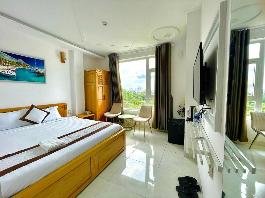 a hotel room with a bed and a tv and a room at Diamond Hotel in Vung Tau