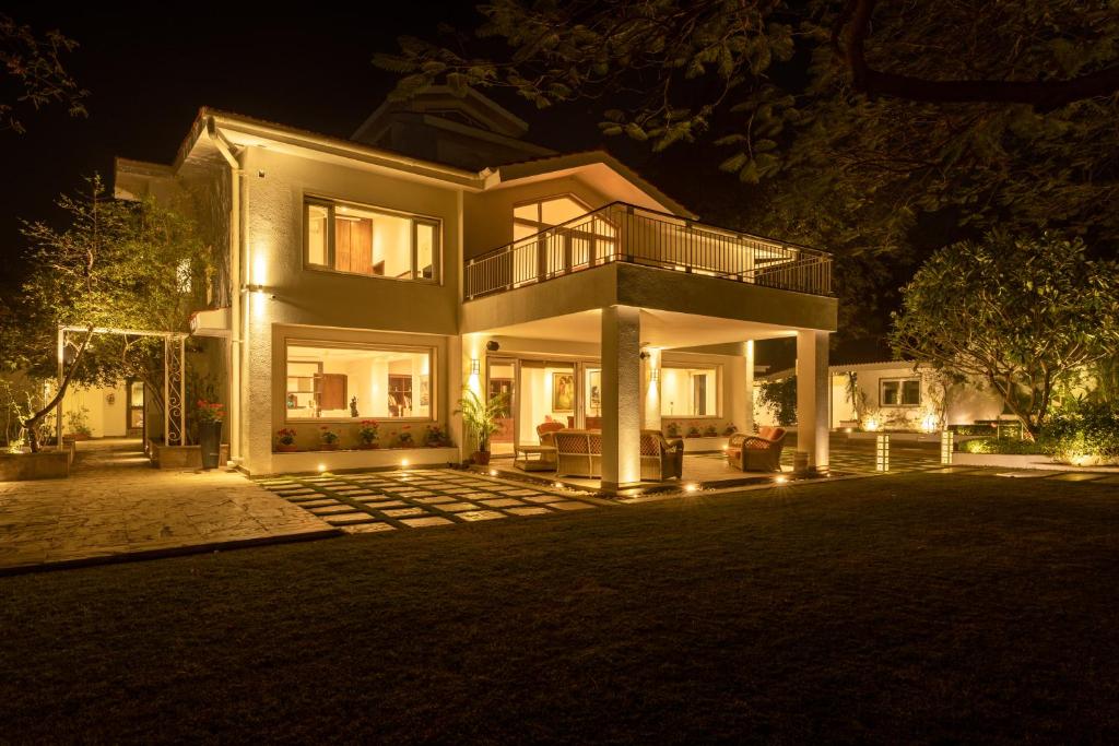 a large house at night with lights at ama Stays & Trails Helen's Garden , Bhopal in Bhopal