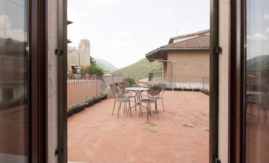 Blick auf eine Terrasse mit einem Tisch und Stühlen in der Unterkunft Casa Vacanze Piantamori in Cerreto di Spoleto
