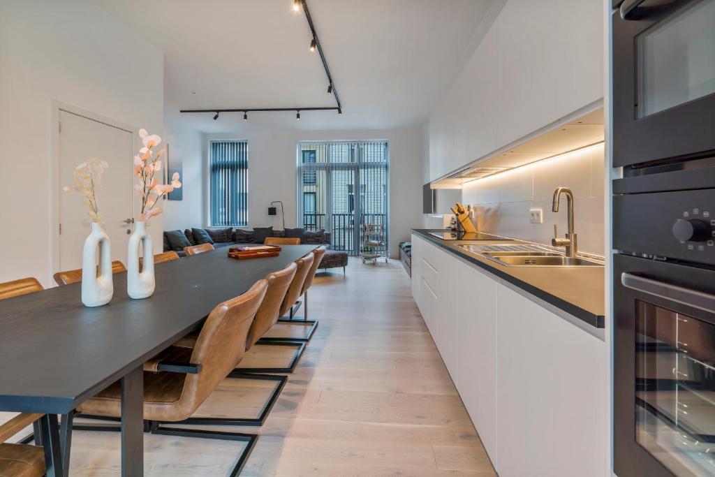 a kitchen and dining room with a dining table at Maison les Bruyères in Blankenberge