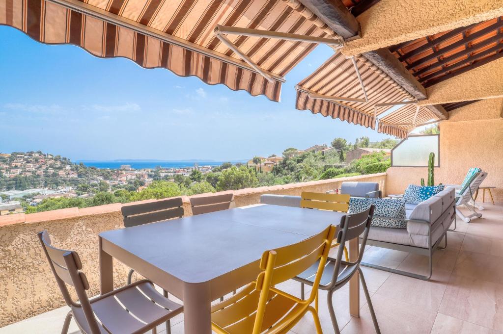 une table et des chaises sur le balcon d'une maison dans l'établissement Superbe T4 -Vue Mer- Tout Confort Refait à Neuf!, à Bormes-les-Mimosas