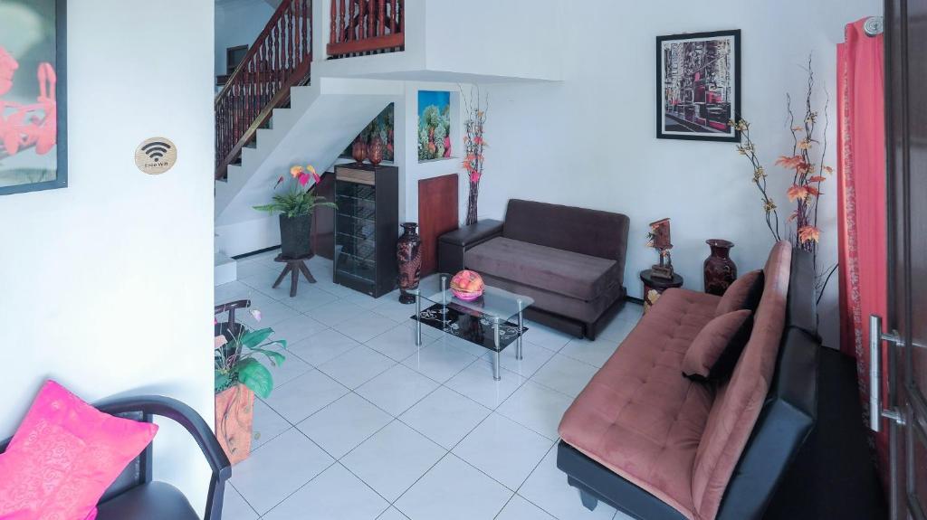 a living room with two couches and a staircase at Villa Malang Puncak Buring in Malang