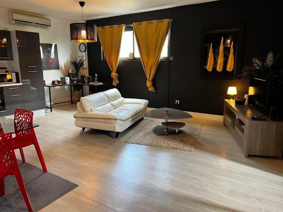 a living room with a white couch and a table at Destination Confidentielle in Clermont-Ferrand