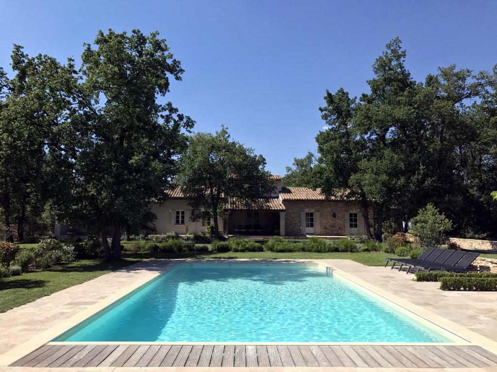 a swimming pool in front of a house at La Bergerie Provencale - Luberon - Provence - villa with heated pool in Roussillon