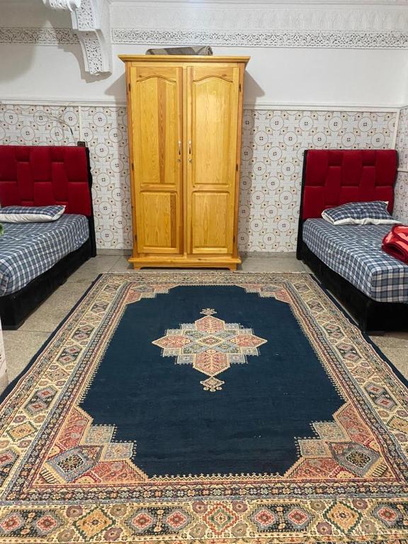 um quarto com duas camas e um tapete no chão em Tranquil Apartment Near Agadir Anza Beach em Agadir