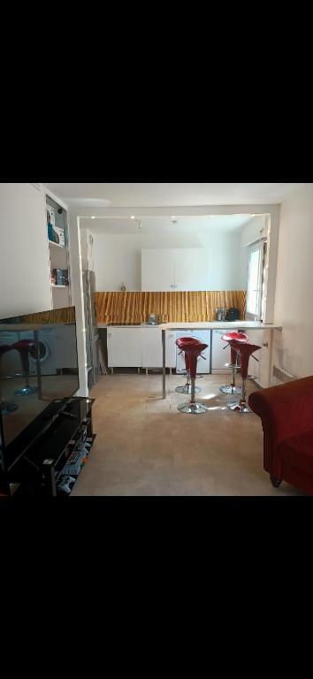 un salon avec deux tables et une cuisine dans l'établissement Petite perle, à Boulogne-Billancourt