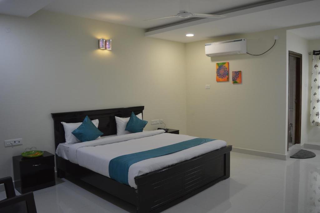 1 dormitorio con 1 cama grande con almohadas azules en HOTEL VIRAT INN en Hyderabad