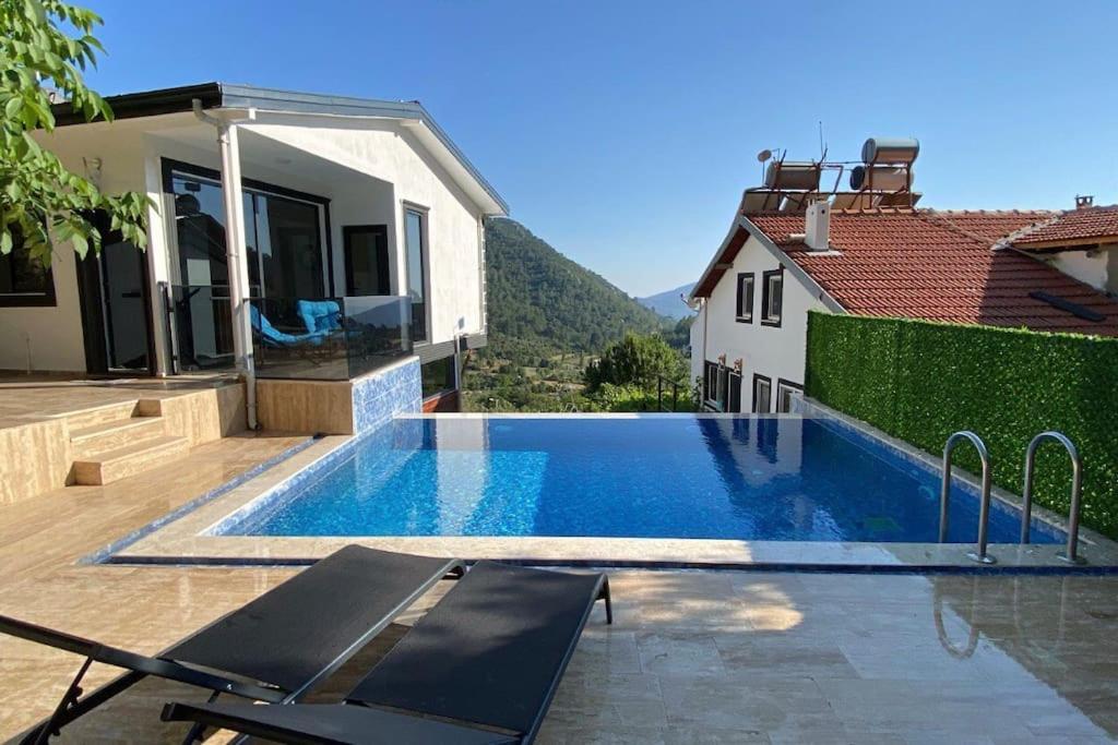 a swimming pool in front of a house at Villa Camgüzeli Kivili Konak’ta! in Fethiye