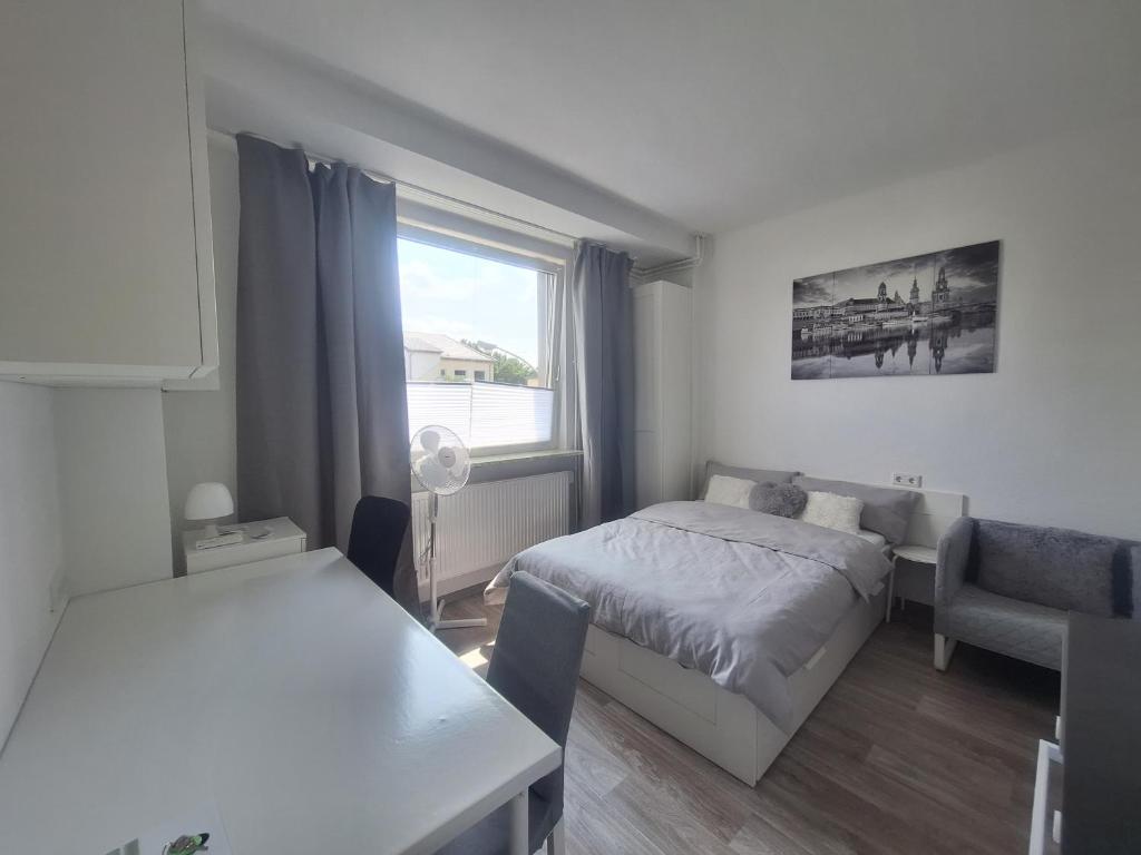 Schlafzimmer mit einem Bett, einem Tisch und einem Fenster in der Unterkunft Apartment 16 - 2R1 in Essen