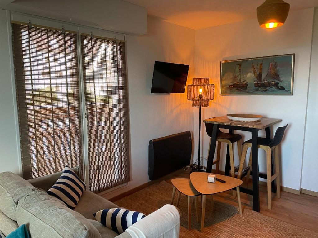 un salon avec un canapé et une table dans l'établissement Joli studio près du front de mer, à Cabourg