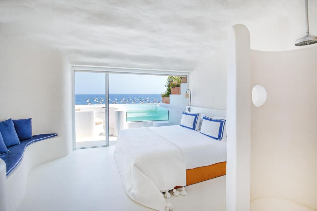 a bedroom with a bed and a view of the ocean at Hotel Isabella's Llafranc in Llafranc