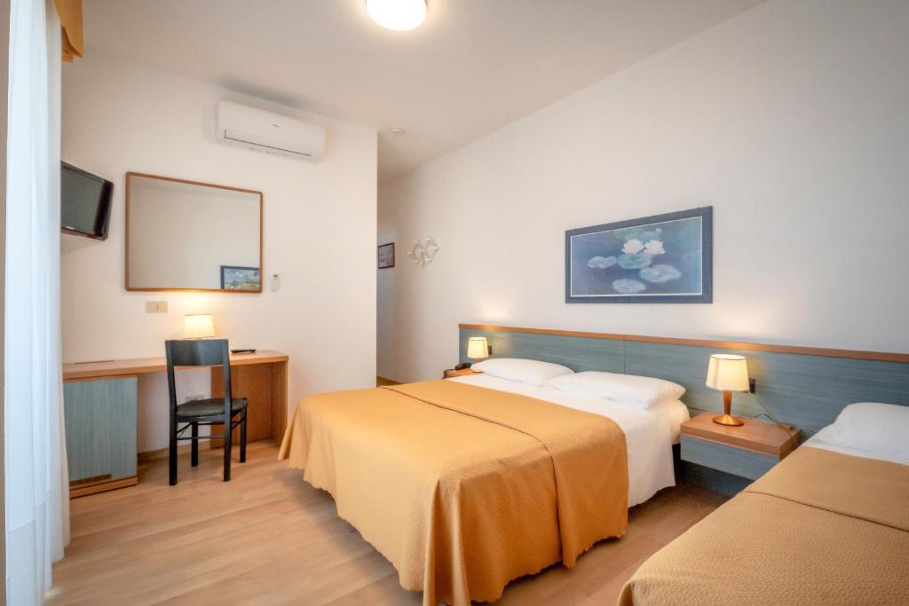 Postel nebo postele na pokoji v ubytování Hotel Parigi