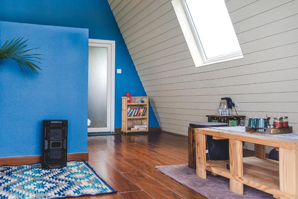 Zimmer mit einem Tisch und einer blauen Wand in der Unterkunft The Soul Stroll Cottages Retreat in Mukteswar