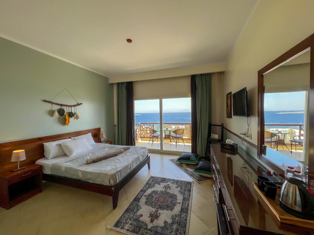 a bedroom with a bed and a view of the ocean at Club Red Dahab Motel in Dahab