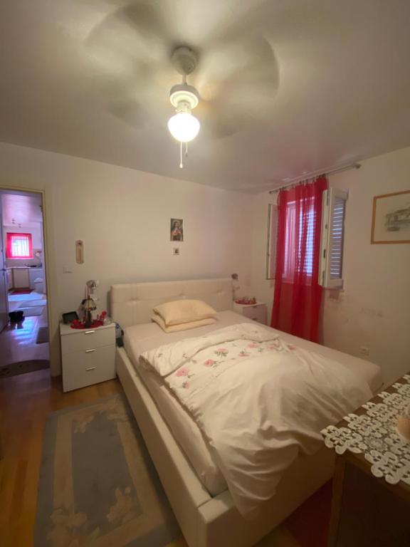 a bedroom with a white bed and a ceiling at Cozy Room + shared kitchen + shared bathroom + free parking in Hvar