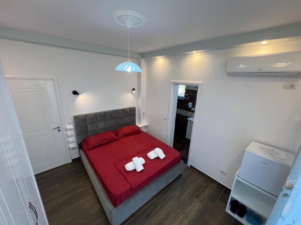 a bedroom with two white towels on a red bed at Adriatik Guesthouse in Përmet