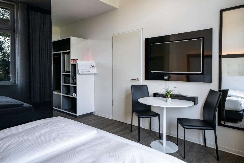 a hotel room with a bed and a table and chairs at INNSiDE by Meliá Leipzig in Leipzig