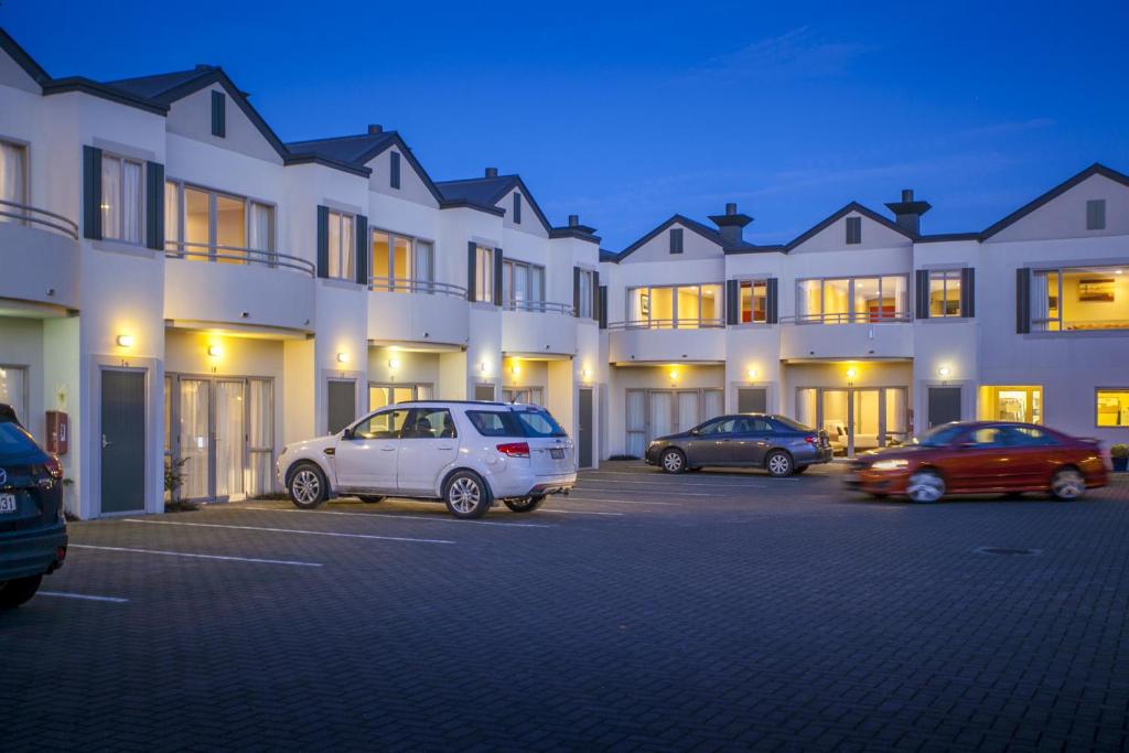 a group of cars parked in a parking lot in front of a building at Cornwall Motor Lodge in Palmerston North