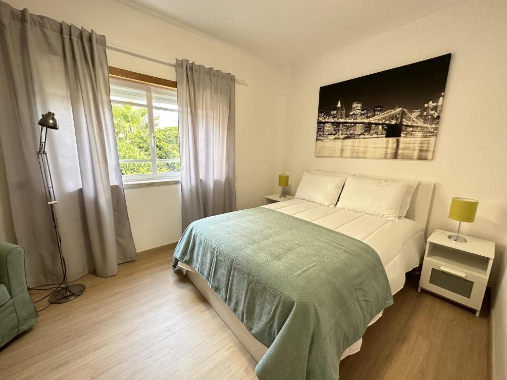 コスタ・ダ・カパリカにあるCaparica's Beach Apartment by Trip2Portugalのベッドルーム(大型ベッド1台、窓付)