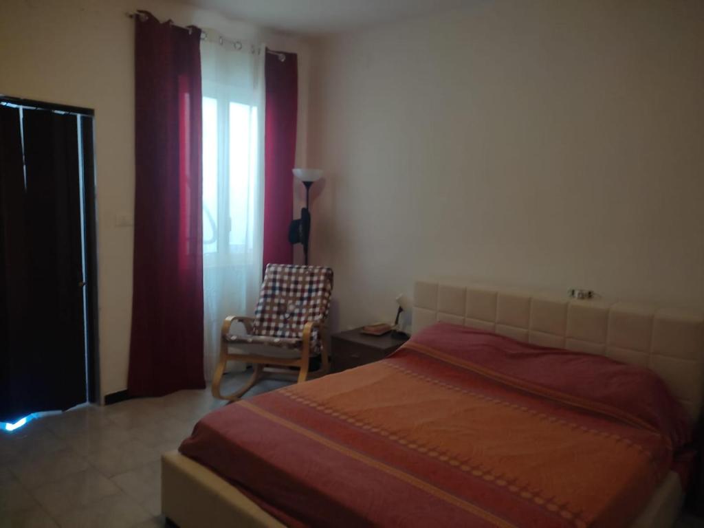 een slaapkamer met een bed, een stoel en een raam bij Spalato 7 HOWME in Bari