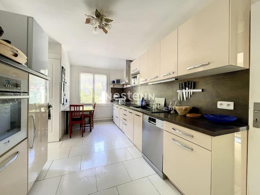 uma grande cozinha com armários brancos e uma mesa em 2948-Maison 8 couchages 600m de la mer em Saint-Cyprien