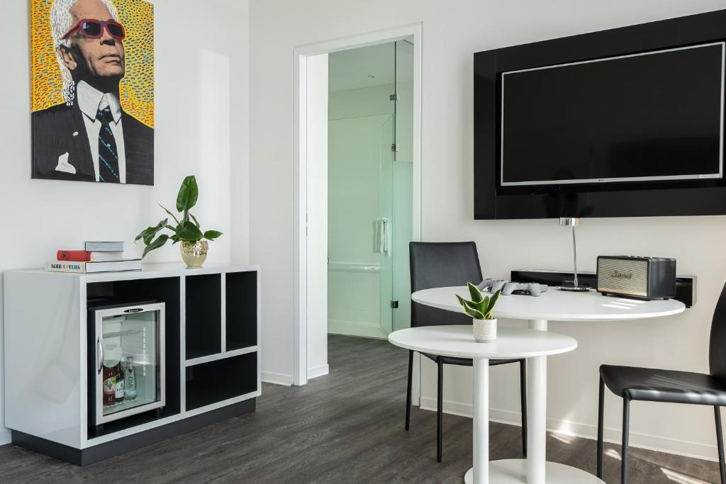 a living room with a fireplace and a tv at INNSiDE by Meliá Leipzig in Leipzig