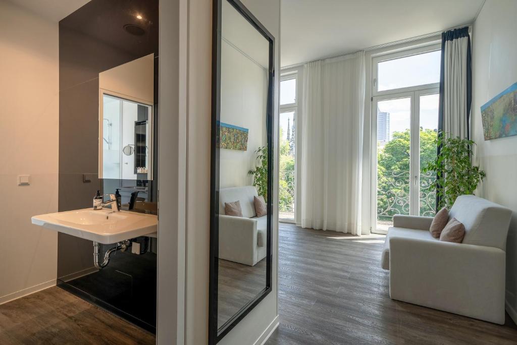 a bathroom with a sink and a mirror at INNSiDE by Meliá Leipzig in Leipzig