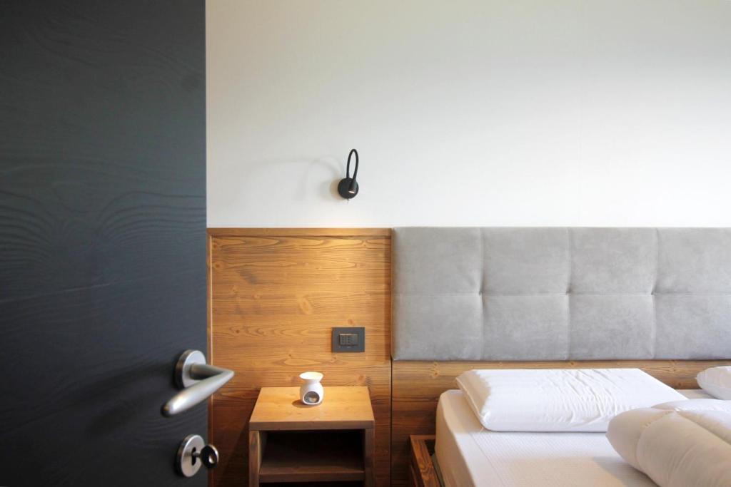 - une chambre avec deux lits, une tête de lit et une table dans l'établissement CASA LOLLY - Piscina - Sauna - Baby Club, à Cavalese