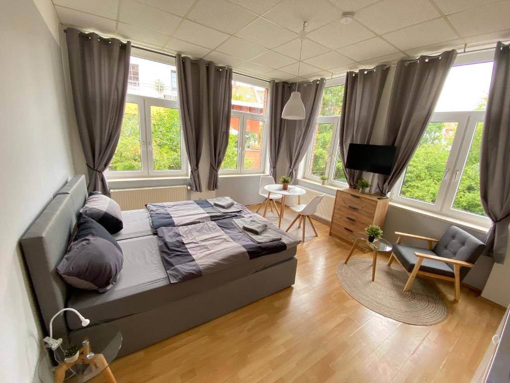 a bedroom with a bed and a tv and windows at City Apartments Erfurt in Erfurt