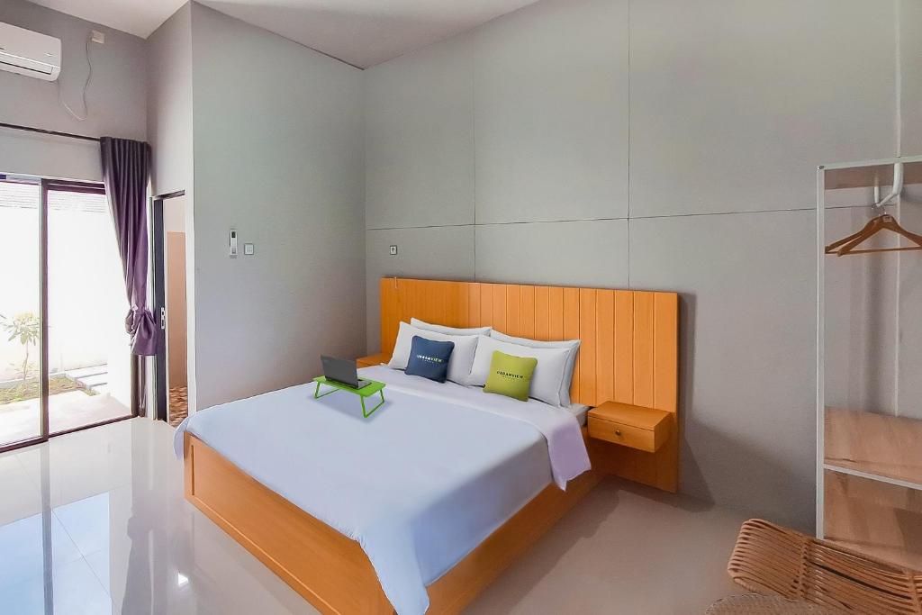 um quarto com uma grande cama branca e uma janela em Urbanview Hotel Griya Menteng Palangkaraya by RedDoorz em Tumbangrungan