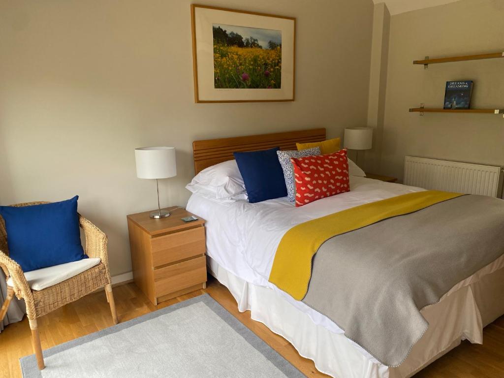 a bedroom with a bed with a chair and a lamp at Two bed barn in Henley in Arden
