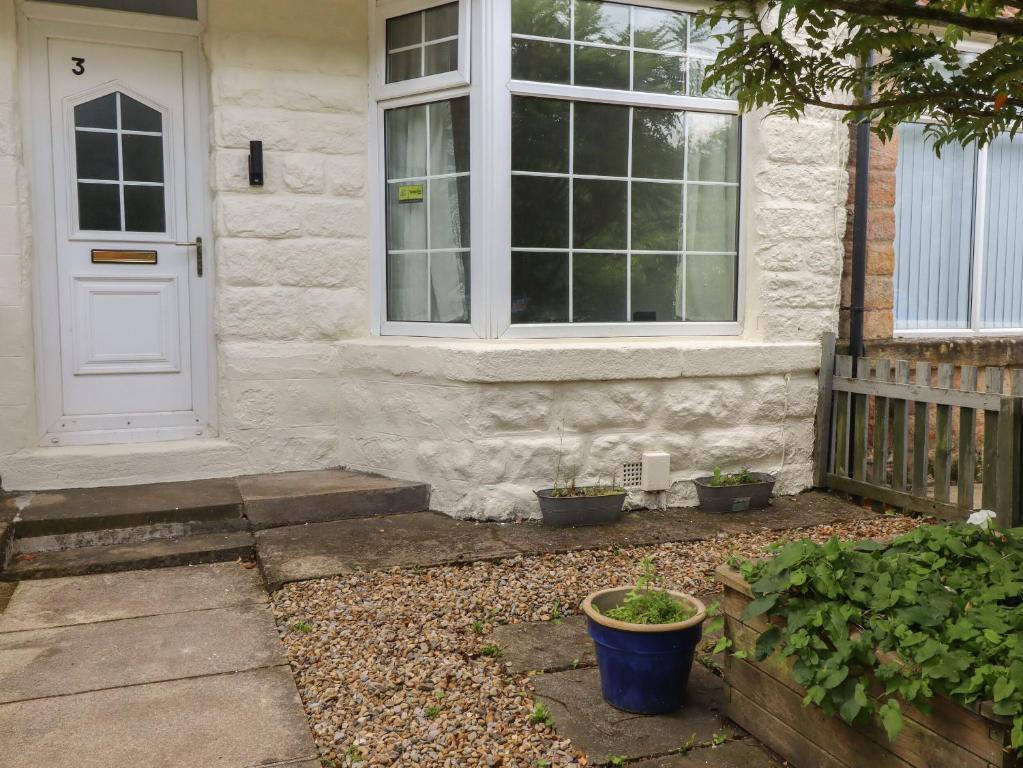 ein Haus mit einer weißen Tür und einem Fenster in der Unterkunft 3 Glendowne Terrace in Harrogate