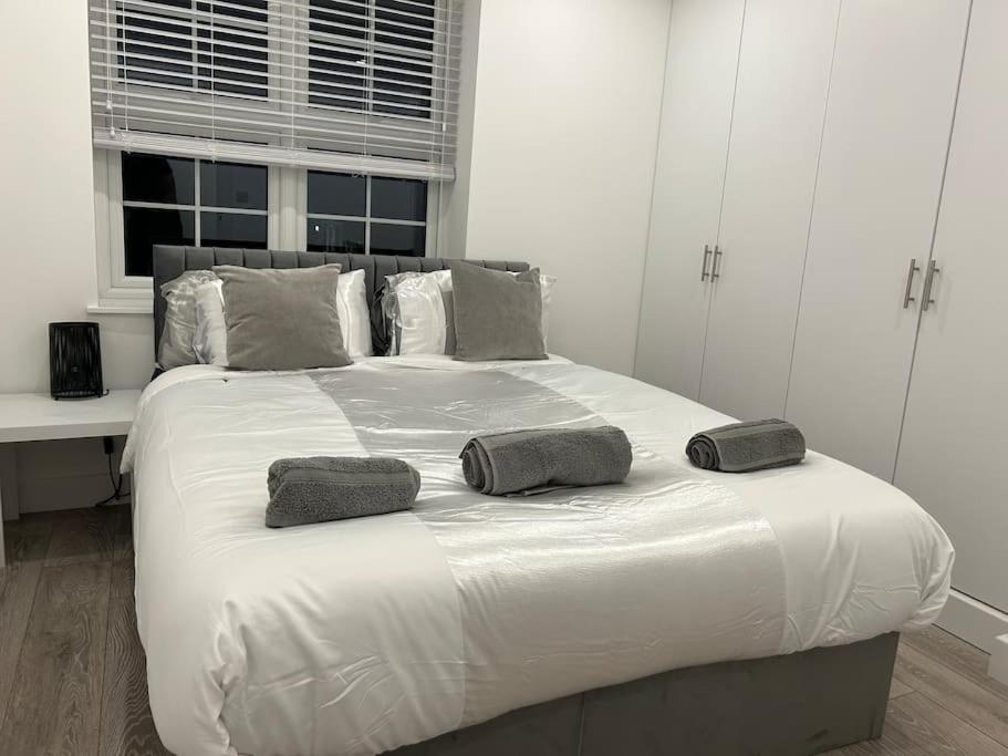 a white bed with two pillows on top of it at 1 bed high quality modern flat in Edgware