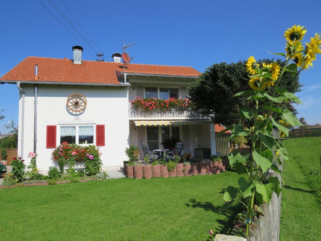 a white house with a clock on the front of it at Gästehaus Reisacher - Mehrbettzimmer in Peiting