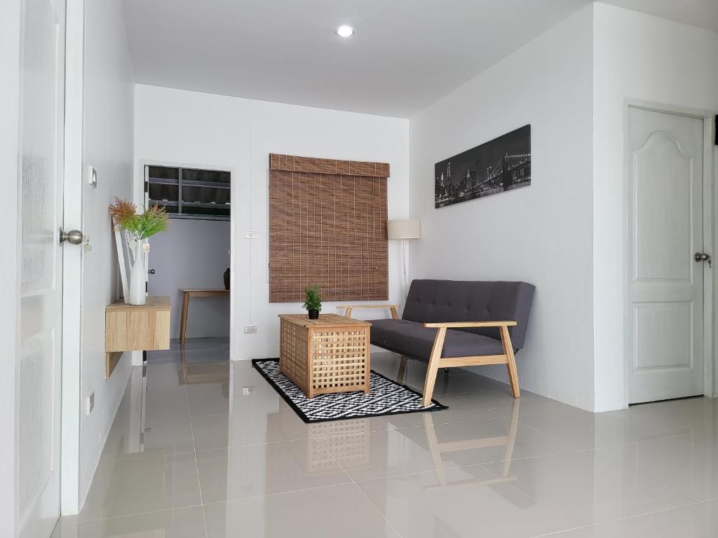 a living room with a couch and a table at Minimal homey 3BR near Mee Chok plaza in Chiang Mai