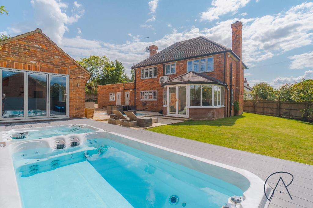 a swimming pool in the backyard of a house at Chic Home, Hot Tub, Hydro Pool & Gym - 15 Mins to Windsor in Warfield