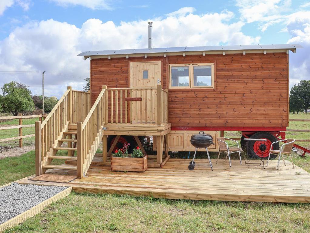 a tiny house with a deck and a grill at Shepherds Hut in Scunthorpe