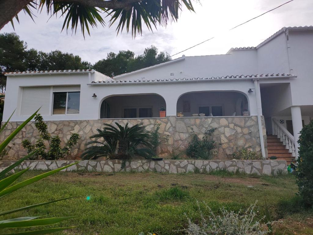 a white house with a stone fence at Apartments in a "VILLA VISTA JAVEA" in Jávea