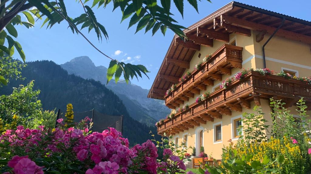 um edifício com uma varanda com flores em Alpen Appartements Oberlehengut - HIDEAWAY em Werfenweng