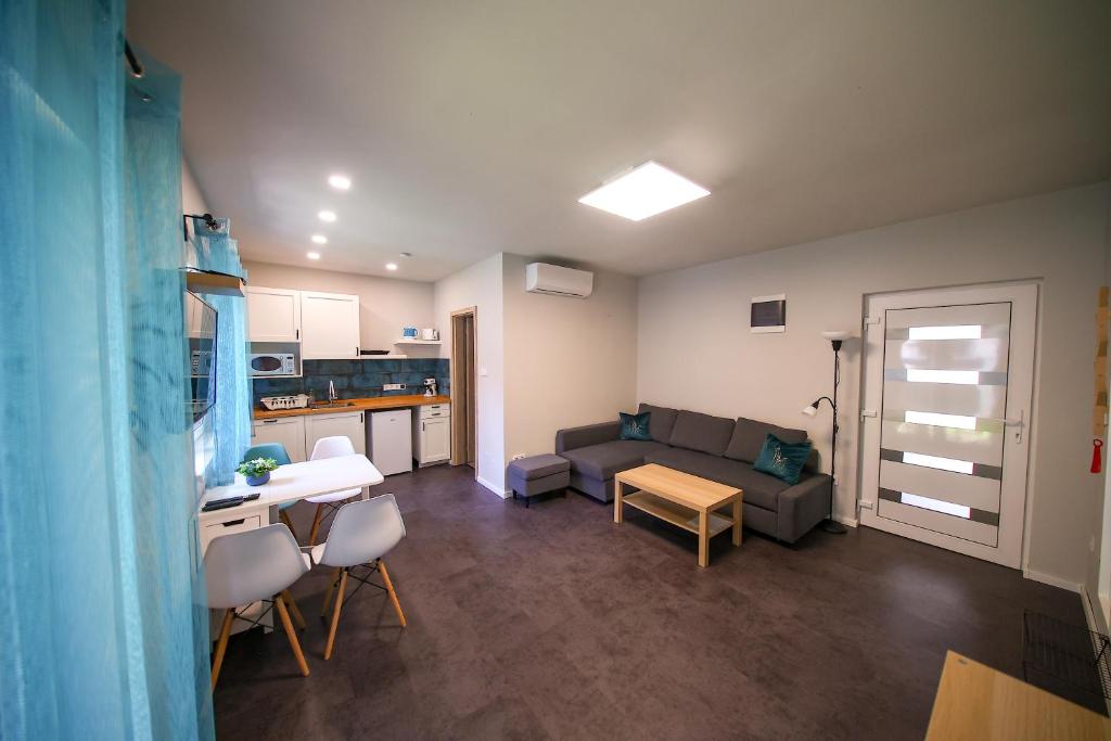 een woonkamer met een bank en een tafel bij Hori Homes Apartman in Siófok