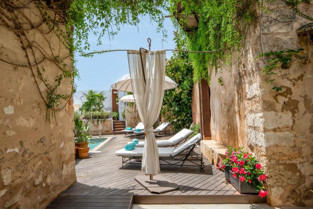 eine Terrasse mit Liegestühlen und einem Sonnenschirm in der Unterkunft Can Joan Capo - Adults Only in Sineu