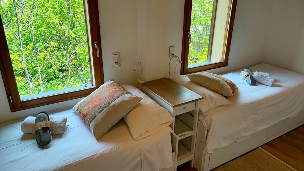 Habitación con 2 camas, escritorio y 2 ventanas. en Casa con jardín cerca de Llívia, en Estavar