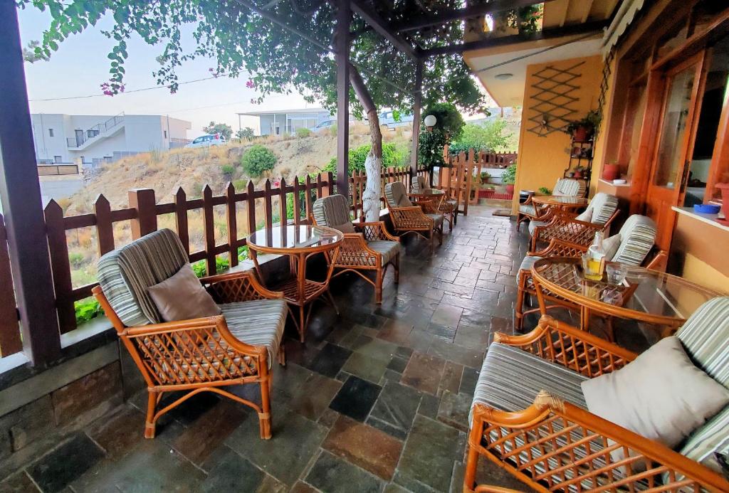 a patio with chairs and tables and a fence at Lappa Hotel in Plakias