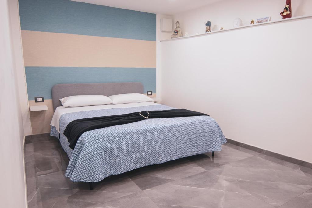 a bedroom with a bed with a blue and white wall at [Centro Storico] Luxury Suites in Naples
